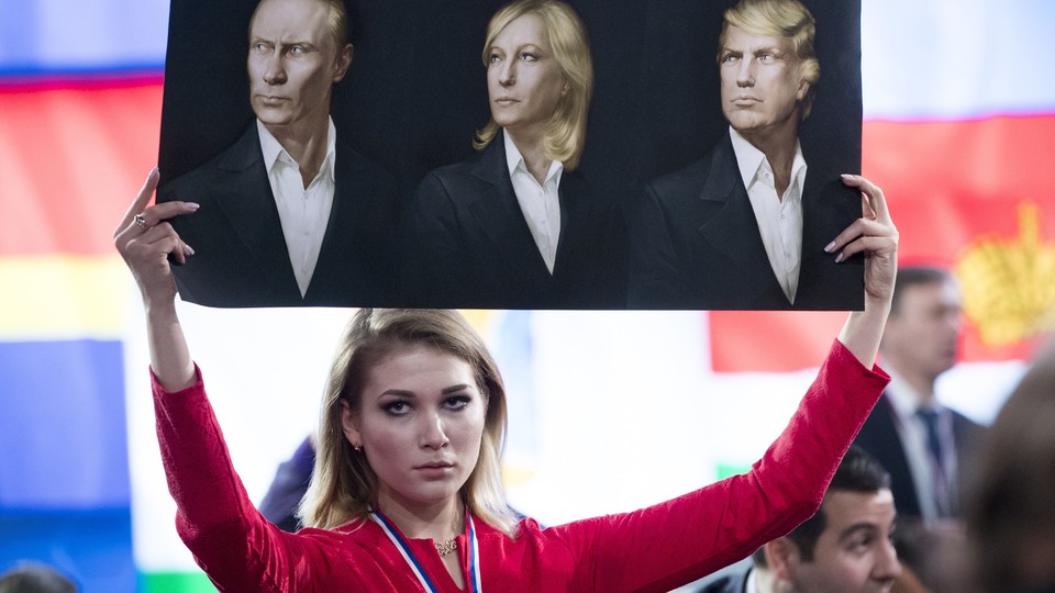 A journalist holds a picture of Vladimir Putin, Marine Le Pen, and Donald Trump at a December news conference in Moscow.