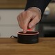 A man mutes an Amazon Echo Dot