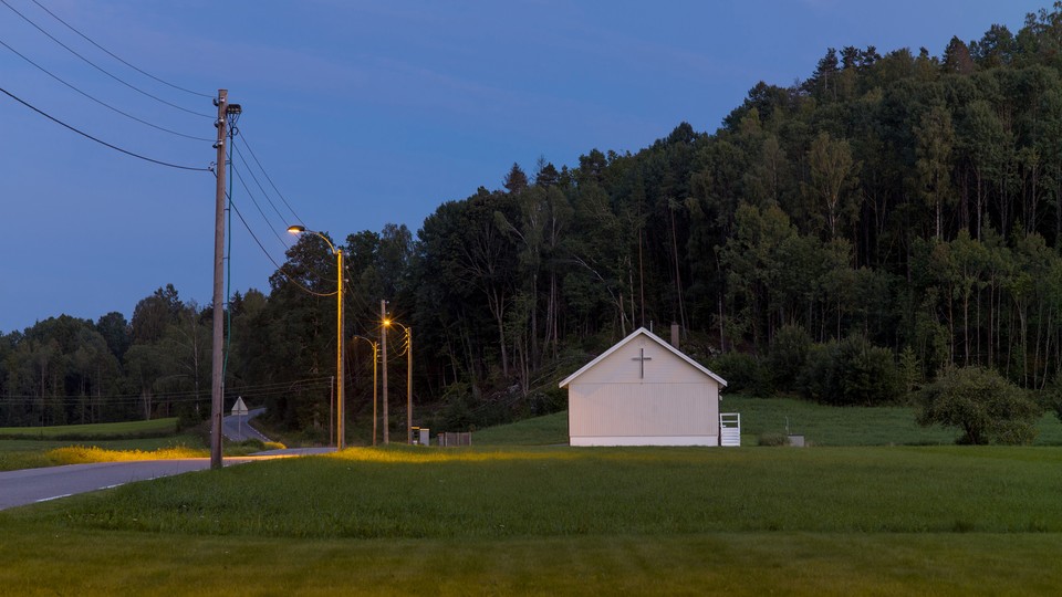 An image of a small church next to a country road.