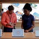 An Apple Store employee assists a customer.