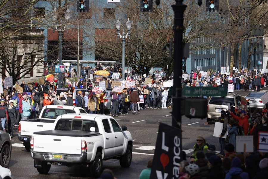 Protesters fill the sidewalks on either side of a city street in Portland, Oregon.