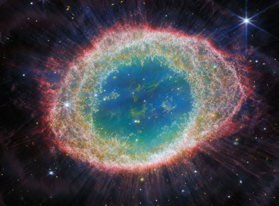 A bright ring-shaped nebula, lined with clouds of gas and dust.