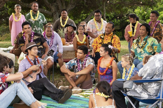 A group of people wearing leis listen to a ukulele player in "Doogie Kameāloha, M.D."