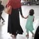 Parents walk with their young children through an airport