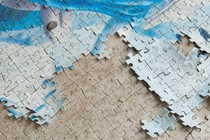 A blue and white puzzle on a beige surface that also has a puzzle imprint