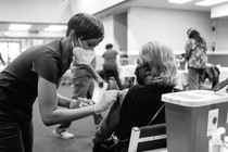 A photograph of an older woman getting vaccinated