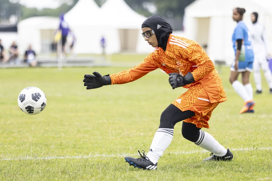 A goalkeeper passes a soccer ball.