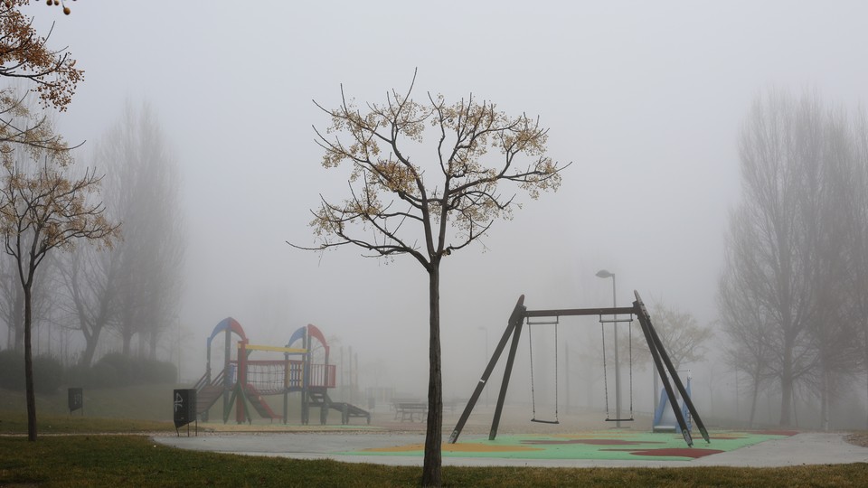 Fog surrounds an empty playground.
