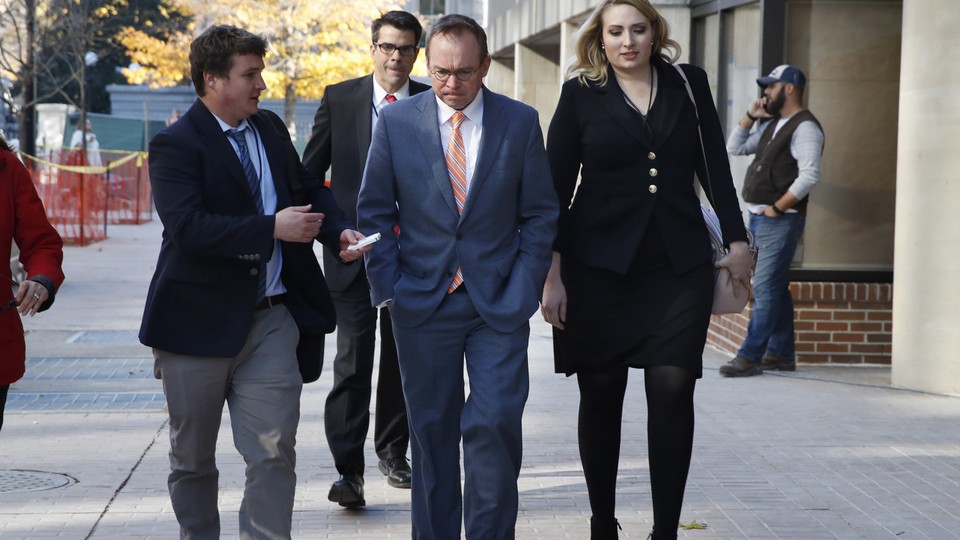 Mick Mulvaney (center) walks to the Consumer Financial Protection Bureau offices in Washington.