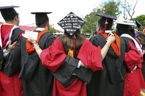 Graduates embrace in caps and gowns at commencement 