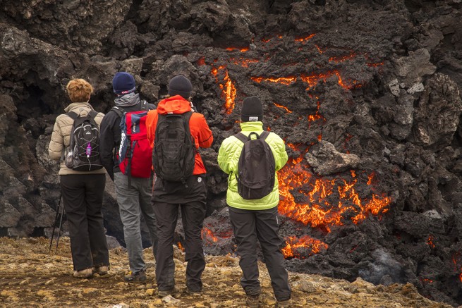 People watching a volcano erupt. 