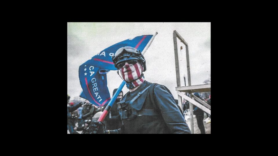 photo of man wearing helmet and goggles with face painted in U.S.-flag stripes carrying Trump MAGA flag with gallows behind