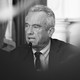 a black and white photograph of Robert F. Kennedy Jr. speaking into a microphone