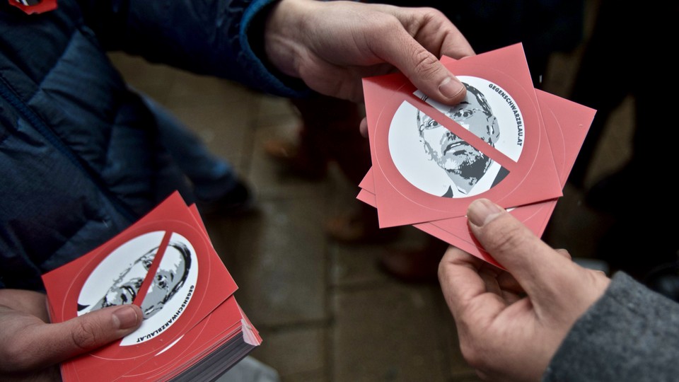 Anti-Kickl demonstrators hand out stickers with his face on them at a rally in Vienna in December 2018.
