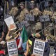 Protesters in LA line up against a wall of National Guard members with shields