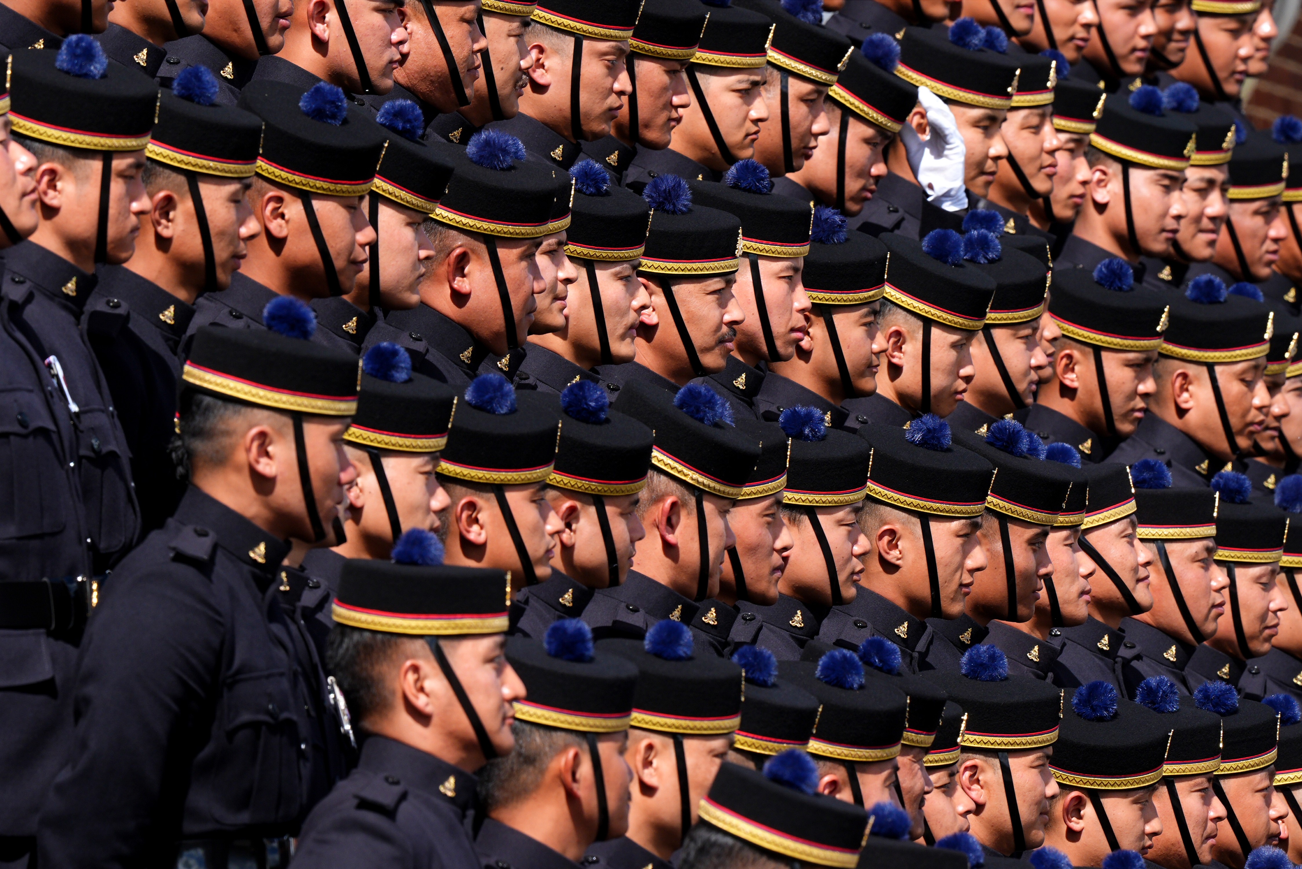 Soldiers in dress uniforms pose together in close rows.