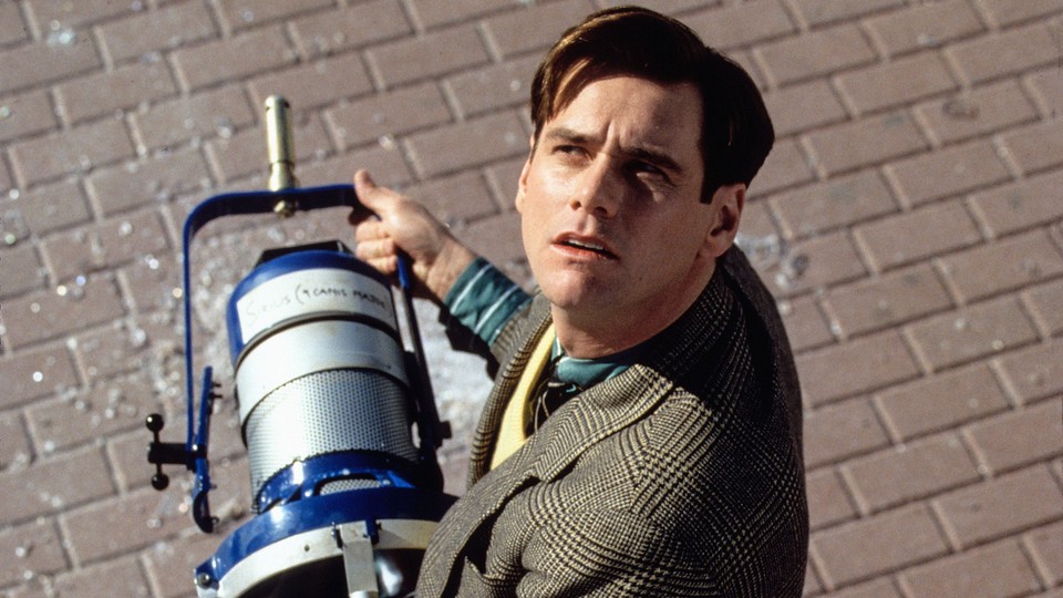 Jim Carrey as Truman Burbank, holding a klieg light that has just fallen from the sky in 'The Truman Show'