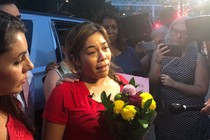 Woman surrounded by reporters 