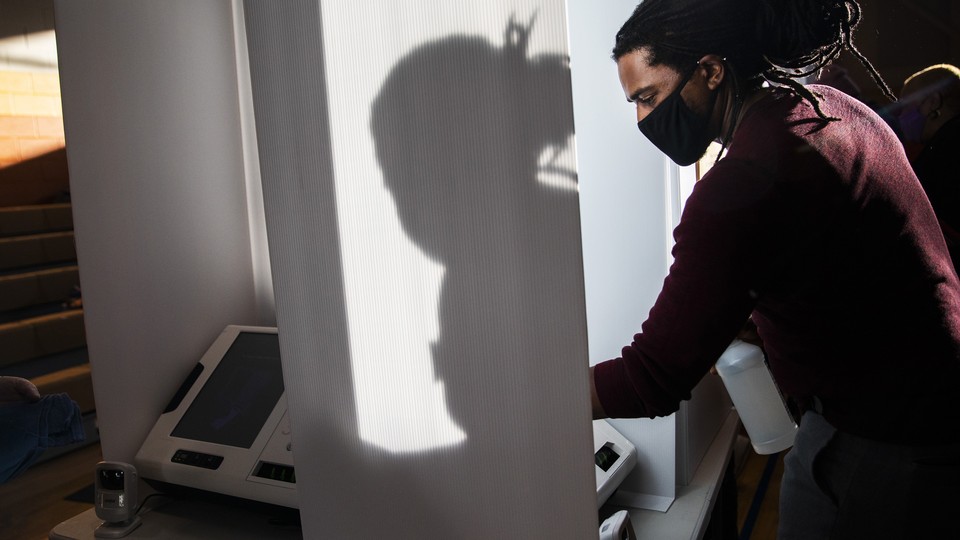 A man cleaning a voting machine for the November 2020 election.