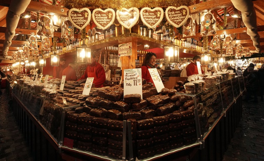 A market stall stocked with gingerbread, fruit bread, and cookies