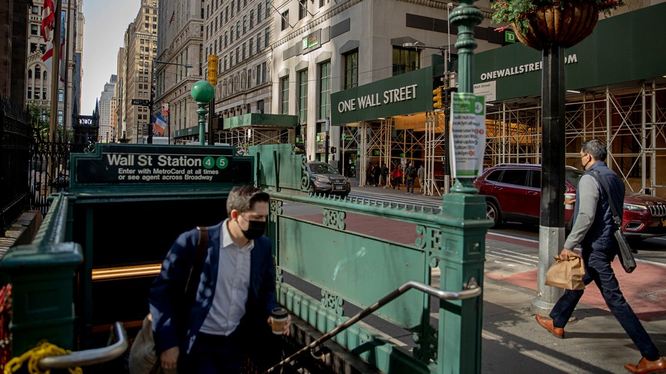 A man with a facemask walking out of a subway stop.