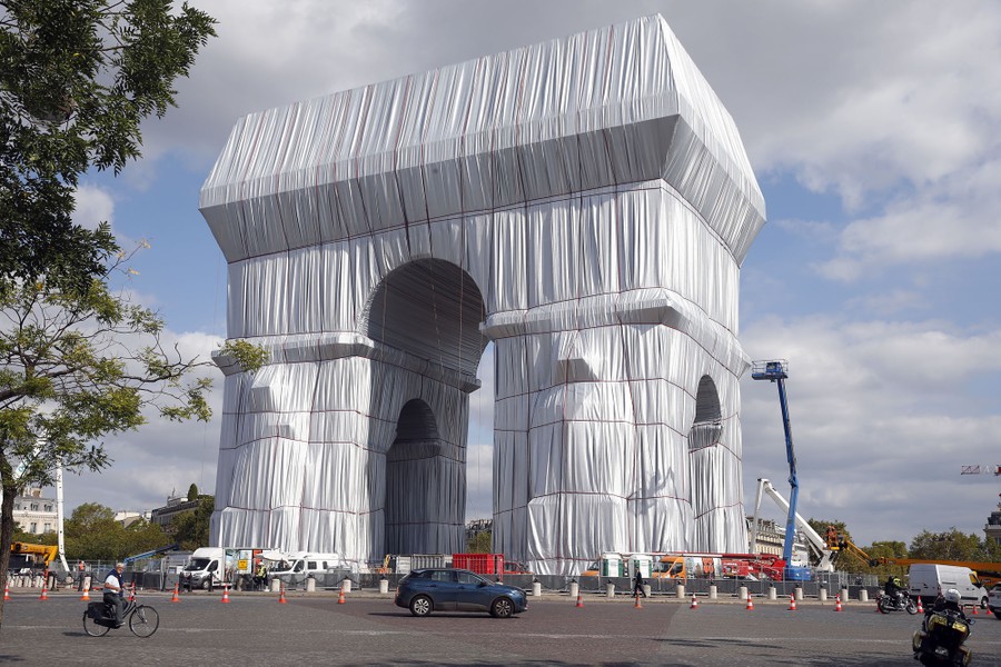 The Arc de Triomphe monument in Paris stands wrapped in vast sheets of fabric.