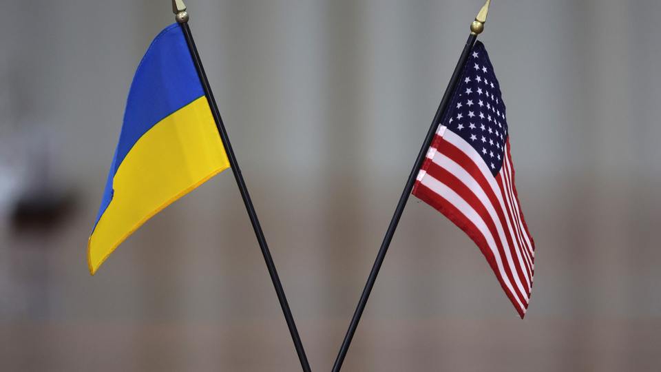 A photo of a small Ukrainian flag besides a small American one