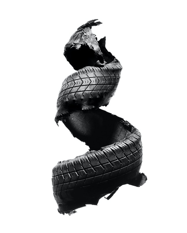 A blown tire shaped into the form of a spiral, against a white background