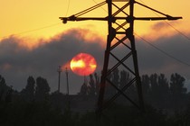 Power lines against a smoky red sky