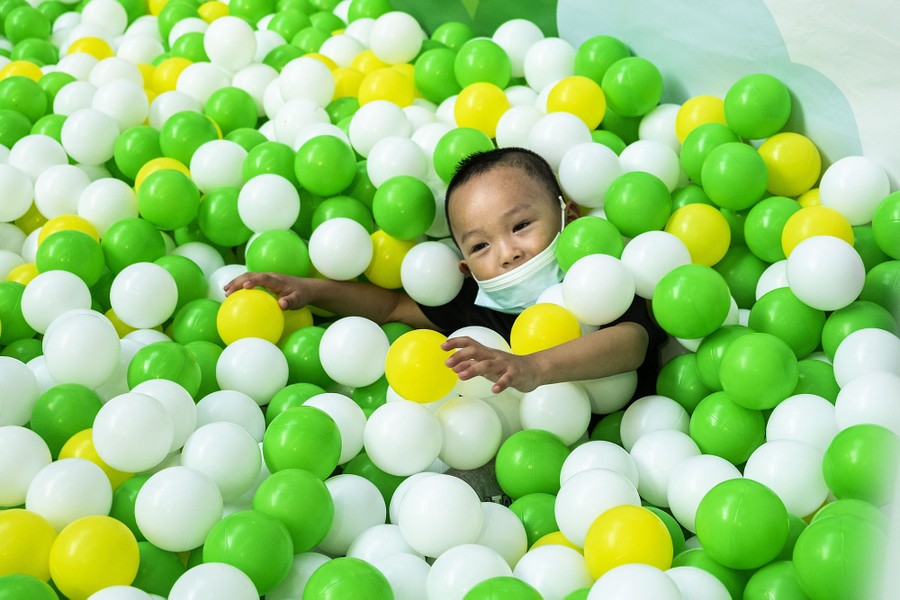A young boy plays in a ball pit.