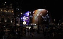 A chart from the James Webb Space Telescope is displayed on a digital billboard on a street at night.