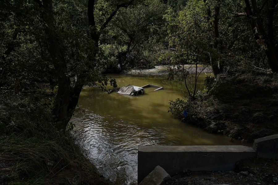 A truck is seen partially submerged in a riverbed.