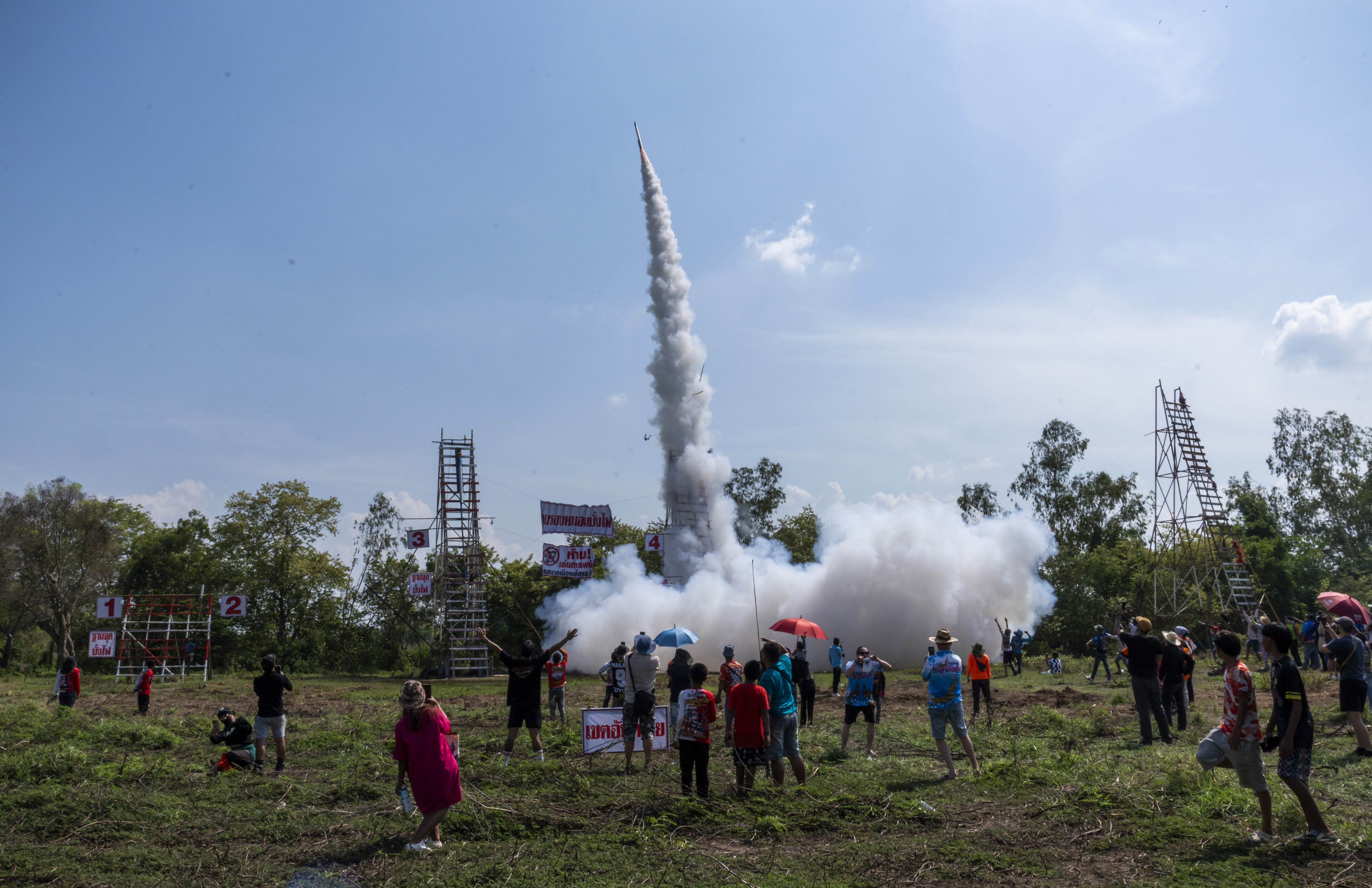 Spectators watch a small rocket launch during a festival.