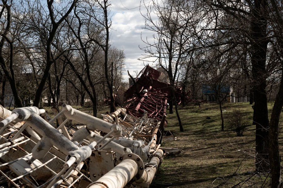 A view along the twisted frame of a tall antenna structure that has fallen to the ground.