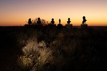 Photo of silhouettes of busts on pedestals during sunset