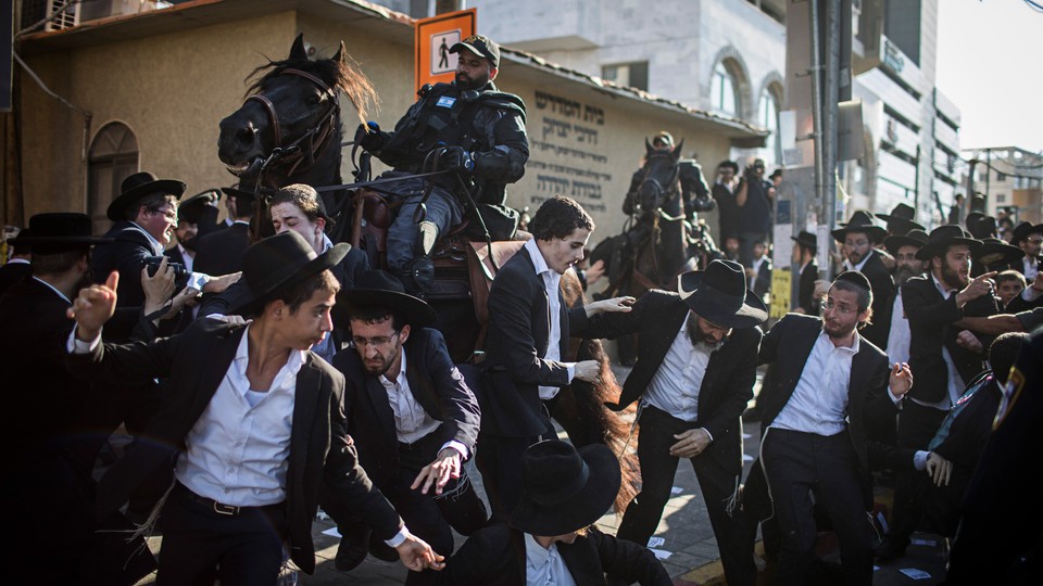 Mounted members of the Israeli security forces try to disperse ultra-Orthodox Jewish protesters as they block a road during a demonstration against army recruitment, in Bnei Brak, Israel, August 6, 2018.