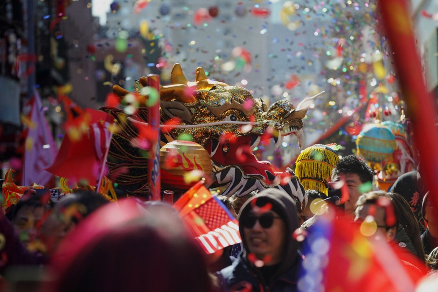 A large dragon puppet amid a crowd during a festive parade