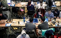 Photo of college students working at their computers as part of a hackathon at Berkeley in 2018