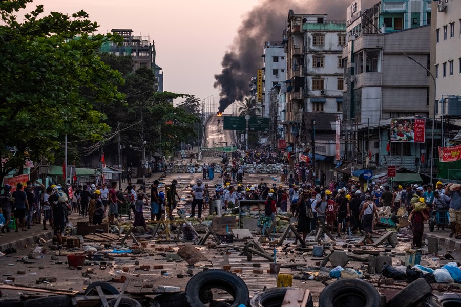 A city street is filled with debris and protesters.