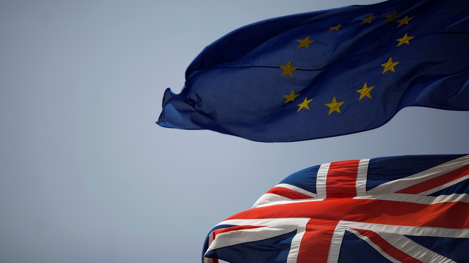The Union Jack (bottom) and the European Union flag (top) are seen flying.