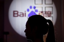 A woman is silhouetted against the Baidu logo