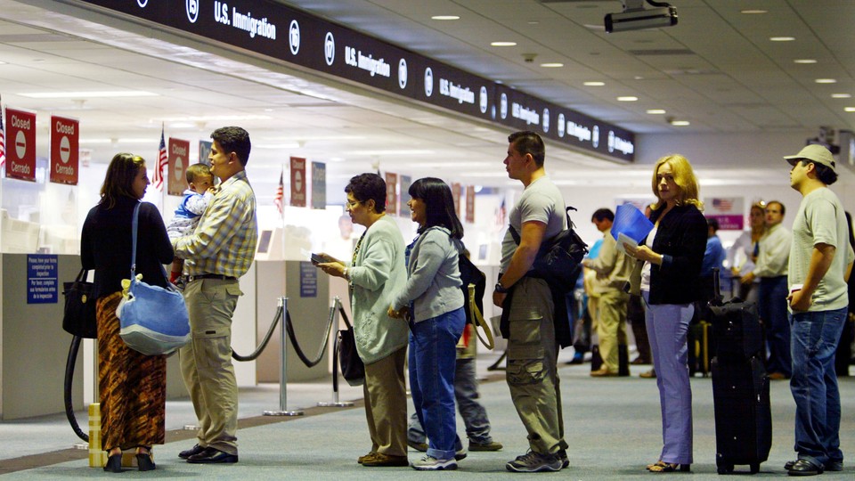 Visitors arriving at the Miami airport wait in line to have their passports checked.