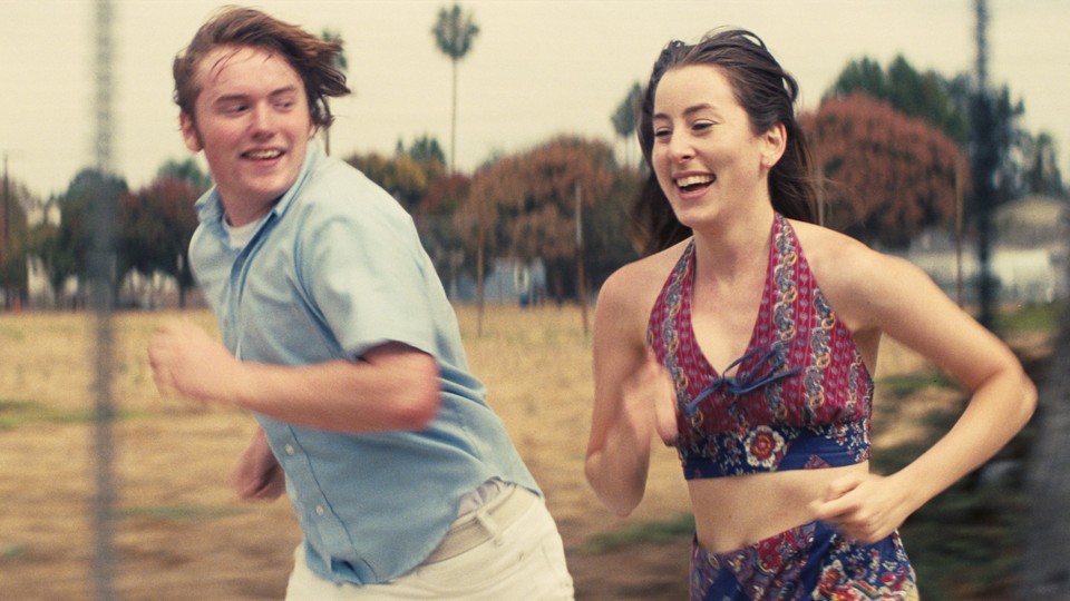 Cooper Hoffman and Alana Haim running outside in "Licorice Pizza"