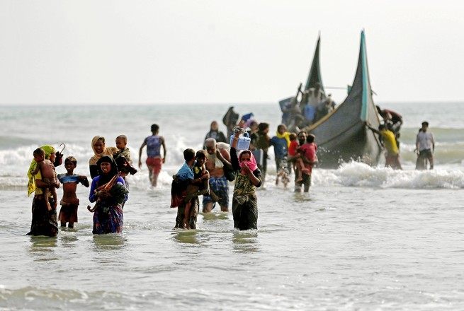 Rohingya refugees walk to the shore after crossing the Bangladesh border by boat on September 5, 2017. (Mohammad Ponir Hossain / Reuters)