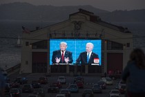 People watch the final U.S. presidential debate between Donald Trump and Joe Biden outside a theater