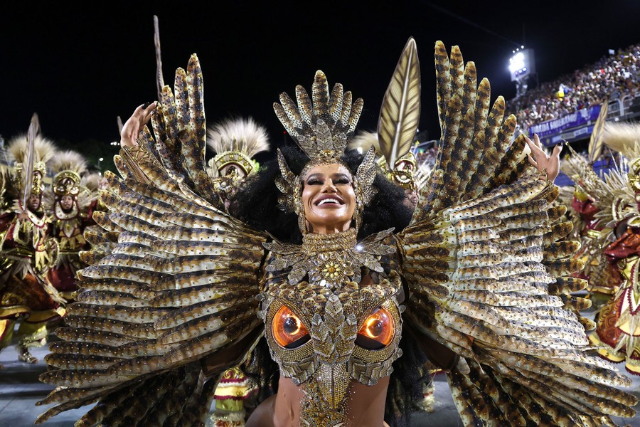 A dancer wearing an owl-themed costume performs in a parade.