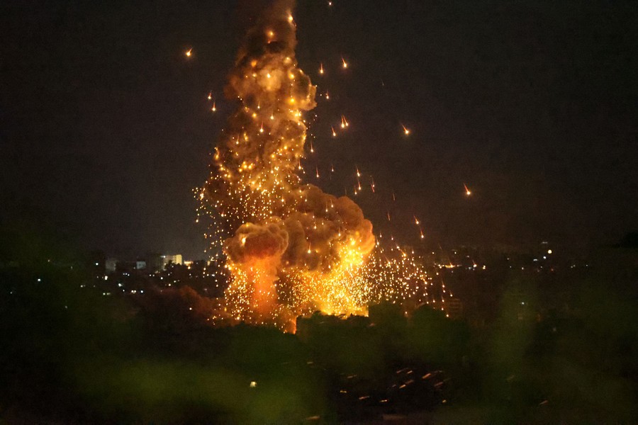 Smoke and sparks rise above an explosion at night, during an Israeli air strike.