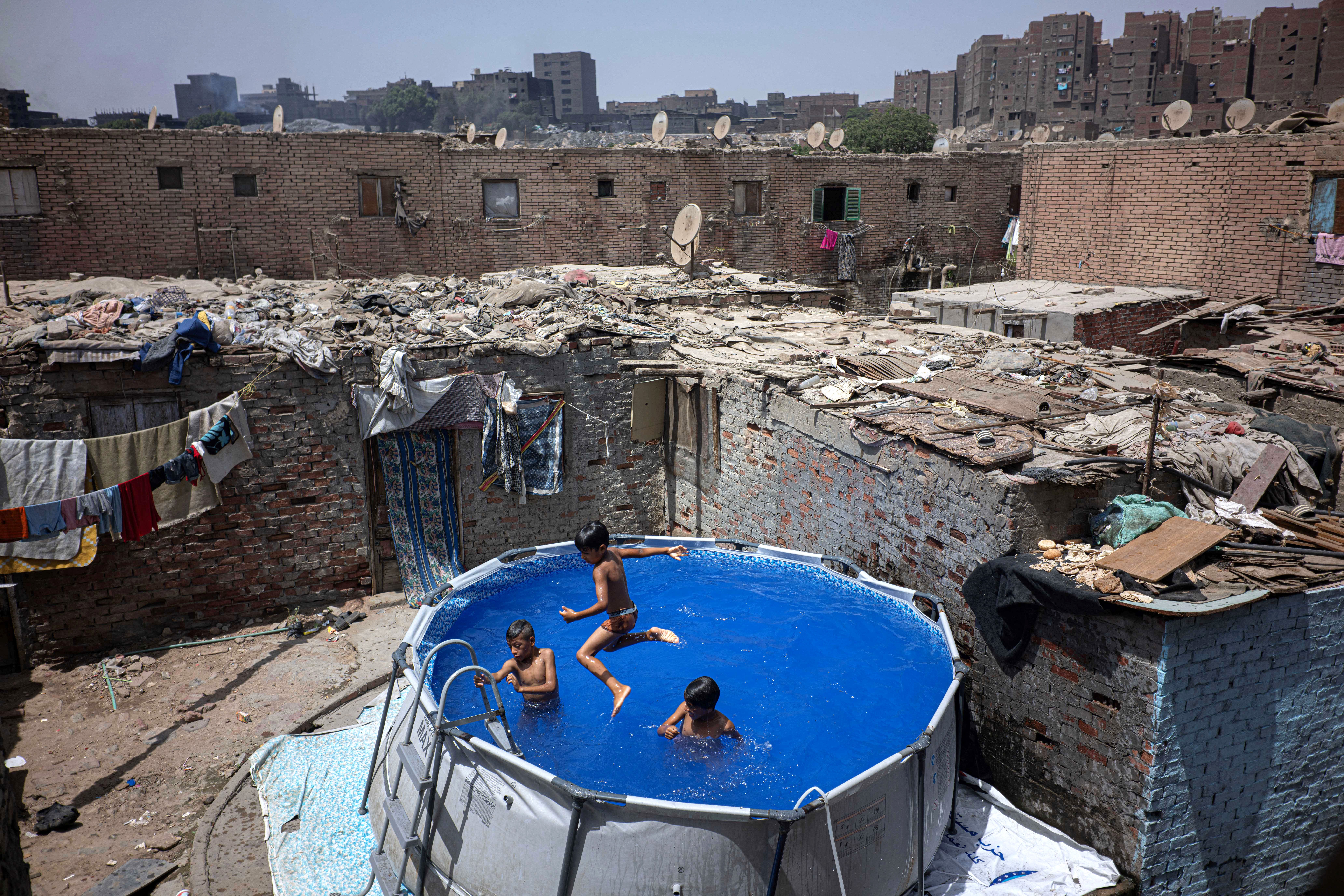 Several children play in a small swimming pool set up in a city in Egypt.