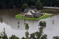 An aerial photo over Amite, Louisiana, shows a home surrounded by water.