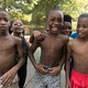 A group of young Black children smile for the camera.